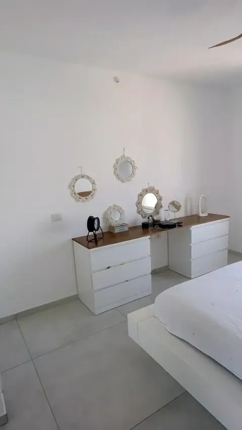 Chambre parentale à Netanya avant : grand mur blanc derrière les commodes